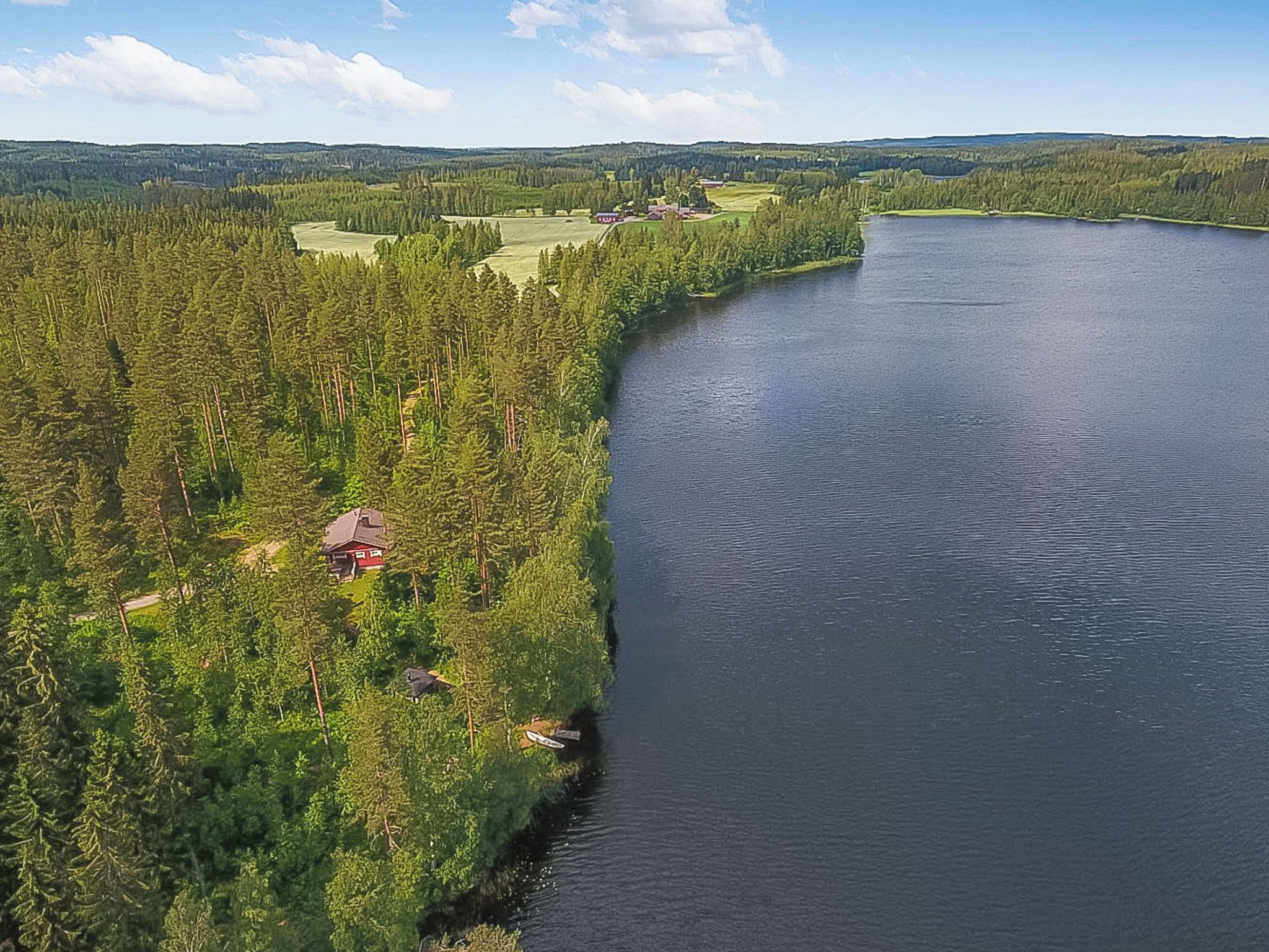 A river with a forested bank and a small building.
