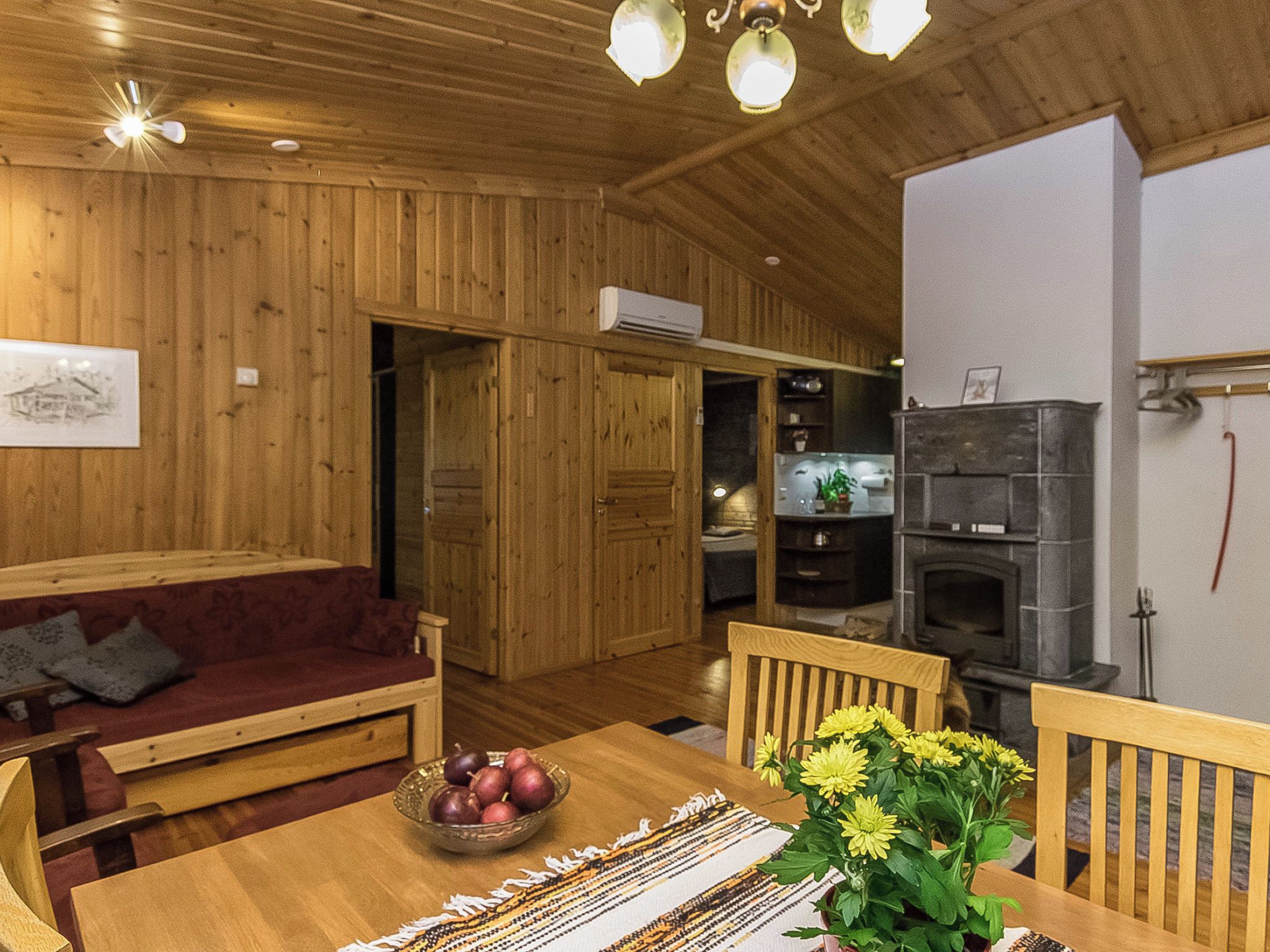 Un interior de madera con una mesa de comedor, un sofá y una cocina con estufa.