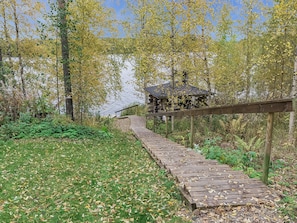 A wooden boardwalk leading to a rustic cabin in a wooded area. - Kytöranta by Interhome (Hartola)