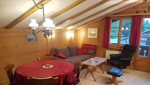 A cozy cabin interior with a dining table, chairs, a sofa, and a chair. - Steimandli by Interhome (Gstaad)