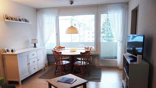 A compact living space with a dining table, chairs, a small TV, and a bookshelf. - Neuschwändi 63 Appartement/Fewo 4-Bettwohnung by Interhome (Engelberg)