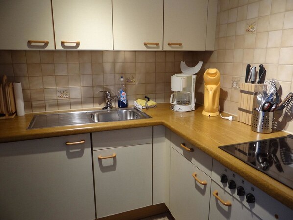 Een koelkast, kookgerei, borden en bestek