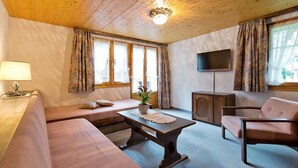 A cozy living room with a sofa, a coffee table, and a TV. - Apartment Maria by Interhome (Saas-Fee)