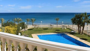 Una piscina con vista sull'oceano e palme.