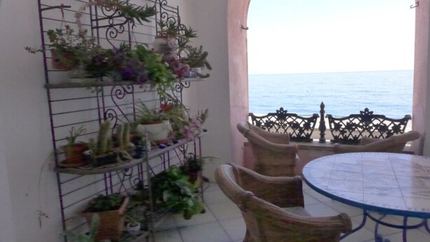A balcony with a metal plant rack, wicker chairs, and a round table. - Casa Bacot - Four Bedroom Villa, Sleeps 8 (Canneto)