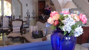 A room with a blue sofa, a blue vase with flowers, and a chandelier. - Casa Bacot - Four Bedroom Villa, Sleeps 8 (Canneto)