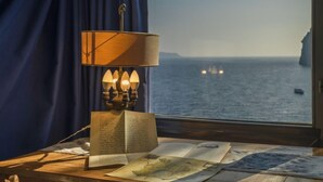 Un bureau en bois avec une lampe, un livre ouvert et des cartes.