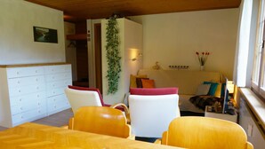 Una sala de estar acogedora con una mesa de comedor de madera, un sofá y una silla.