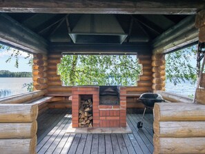 A log cabin with a brick fireplace and a grill, overlooking a lake. - Männikkö by Interhome (Sulkava)