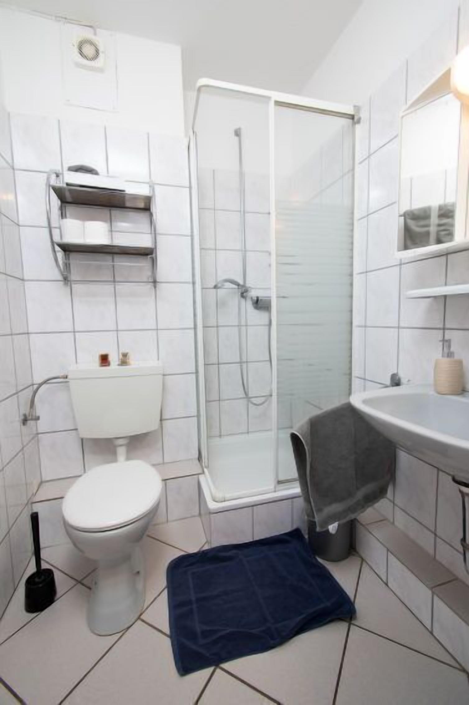 A bathroom with a toilet, a shower, and a sink.