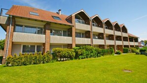 Un edificio de varios pisos con techo plano y ventanas grandes.