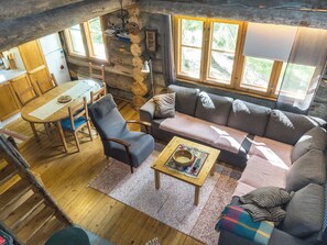 A cozy cabin interior with a dining area, sofa, and a table with a bowl. - Ukkohermanni by Interhome (Sodankylä)