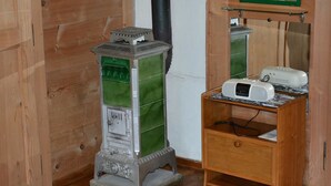 Ein Zimmer mit Holzboden, einem kleinen Holzkästen mit Schublade und einem Heizkörper im Vintage-Stil mit grüner Glasfront.