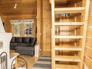 A wooden interior with a sofa, a small table, and a built-in shelving unit.
