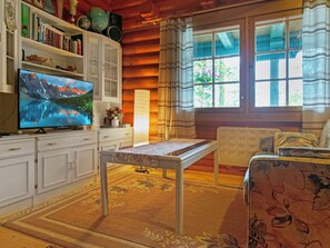 Een gezellige woonkamer met een televisie, een tafel en een bank.