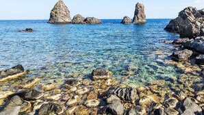 A rocky shoreline with clear blue water and large rock formations. - Gondar Studio by Interhome (Aci Trezza)