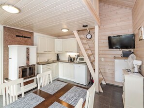 A compact kitchen with white cabinets, a built-in microwave, and a small refrigerator.