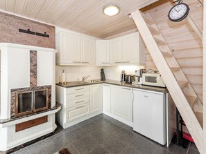 A compact kitchen with white cabinets, a built-in stove, and a microwave.