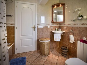 A bathroom with a white door, a sink, a mirror, and a toilet. There are wicker baskets and a blue towel on the floor. - Villa Buena Vida by Interhome (Dénia)