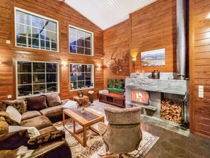 A cozy log cabin interior with a fireplace, wooden walls, and a comfortable seating area. - Arctic chalet by Interhome (Ylläsjärvi)