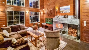 A cozy living room with wooden walls, a fireplace, and a television. - Arctic chalet by Interhome (Ylläsjärvi)