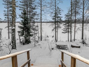 Un espace extérieur enneigé avec un banc en bois et une rambarde en bois.