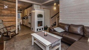 Una sala de estar acogedora con un sofá de cuero marrón, una mesa de centro blanca y una chimenea.