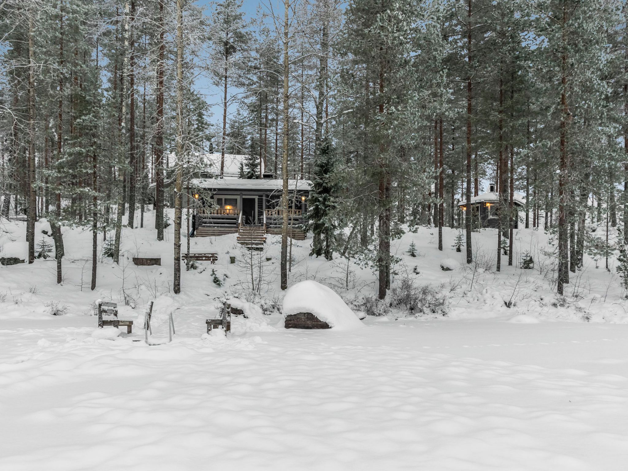 Una baita circondata da alberi innevati.