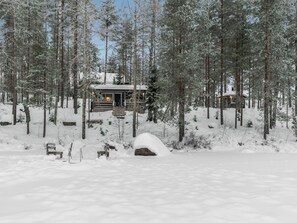 Une cabane entourée d’arbres couverts de neige.