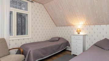 Un dormitorio pequeño y acogedor con dos camas, una mesita de noche, una silla y una ventana con persianas.