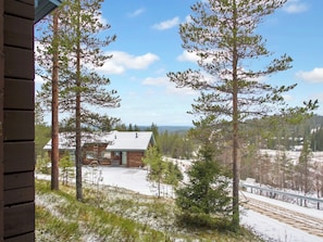 A cabin with a wooden exterior, surrounded by snow-covered ground and trees. - Rukan vaarala 2 c 3 by Interhome (Kuusamo)