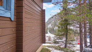 A wooden cabin with a blue window, a snowy landscape, and a mountain in the background. - Rukan vaarala 2 c 3 by Interhome (Kuusamo)