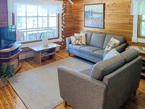 Una sala de estar acogedora con un sofá, una mesa de centro y un televisor.