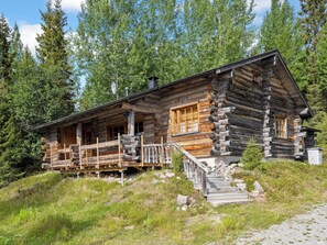 A log cabin with a porch, wooden steps, and a chimney. - Luminalle by Interhome (Kuusamo)
