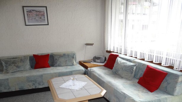 Ein Wohnzimmer mit einer Couch, einem Couchtisch und einem Radio.