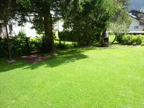 A well-maintained grassy lawn with a stone pathway leading to a building. - Steinacher Appartement/Fewo 5-Bettwohnung by Interhome (Engelberg)
