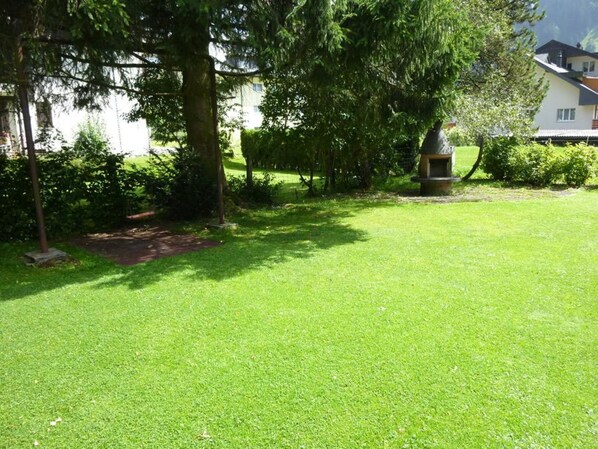 A well-maintained grassy lawn with a stone pathway leading to a building.