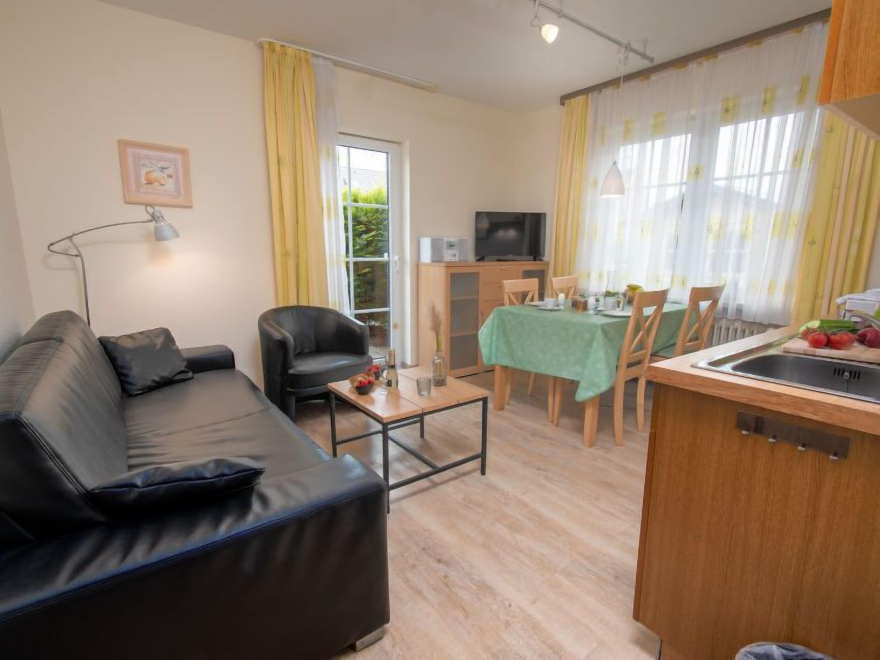 A compact living space with a sofa, a dining table, and a kitchenette.
