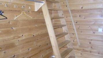 Un intérieur en bois avec un escalier et un portant en métal.