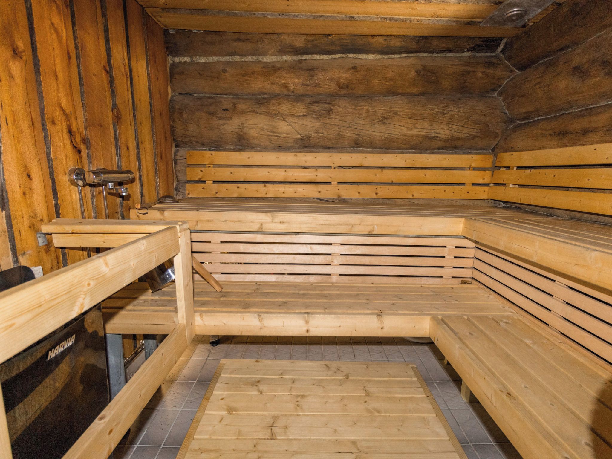 Sauna, jossa on puiset lauteet ja metallinen kiuas.