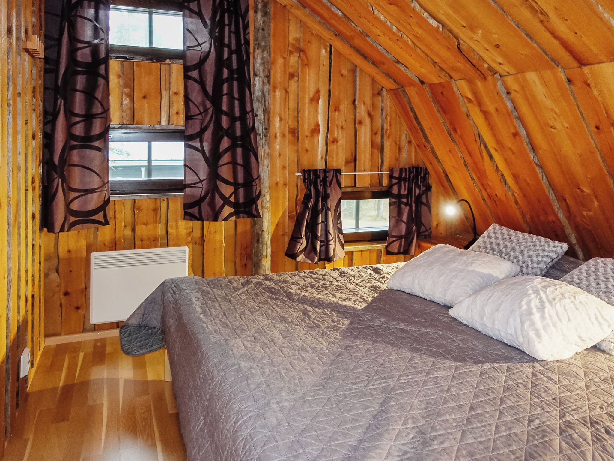 Une chambre confortable située dans les combles, avec un lit, deux fenêtres et un radiateur.
