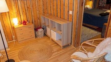 Une pièce confortable avec un lit, un bureau, une chaise et un téléviseur fixé au mur.