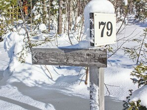 A wooden signpost with a white number plaque indicating '79' and a directional arrow pointing left.