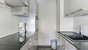 A modern kitchen with a coffee maker, a trash bin, and a sink. - Le Bec Rouge (Le Lac) by Interhome (Tignes)