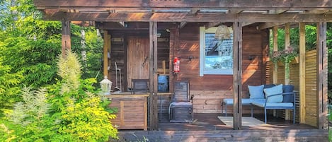 Une cabane en bois avec un porche couvert, un extincteur et un tableau encadré accroché au mur.