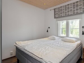Een slaapkamer met een bed, een raam en een ventilatie rooster.