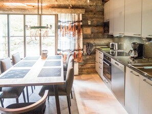 A rustic kitchen with a dining table, chairs, and a view of the outdoors.