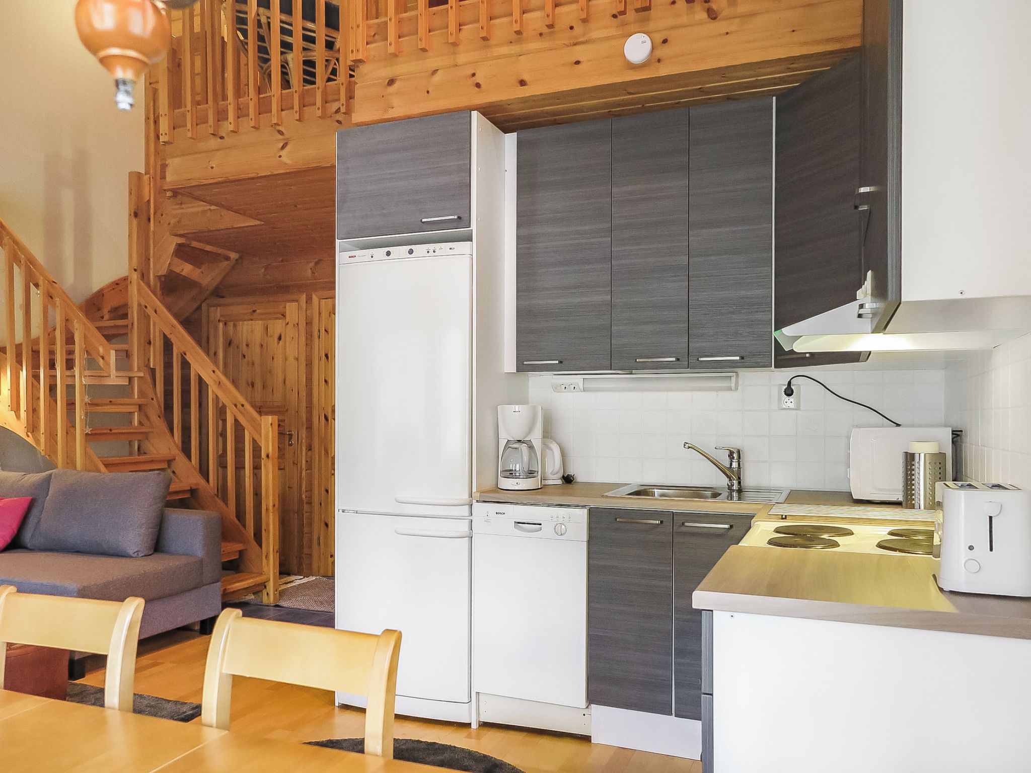 A compact kitchen with a Bosch dishwasher, a coffee maker, and a toaster.