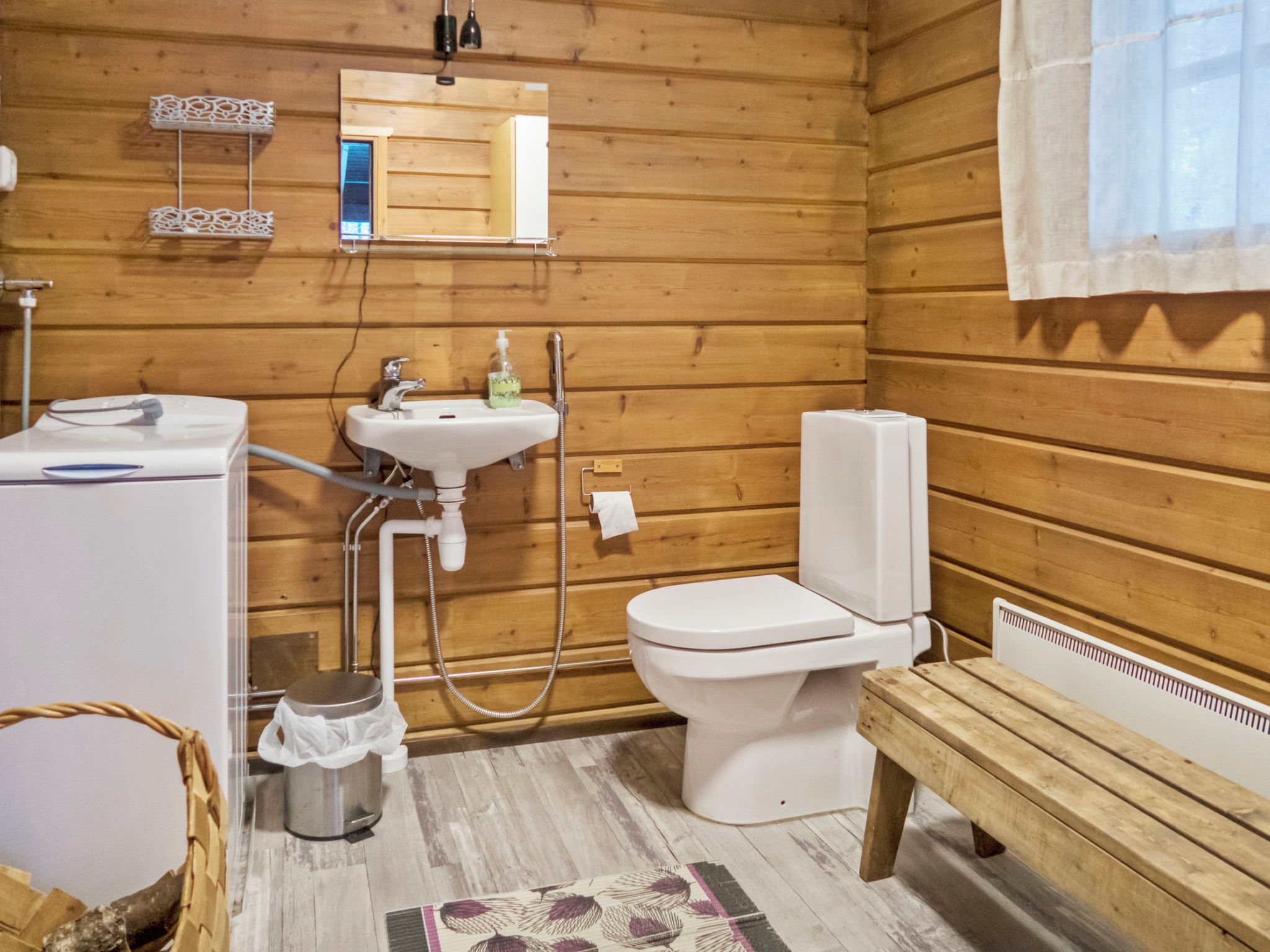Een kleine badkamer met een wastafel, toilet en een bankje.