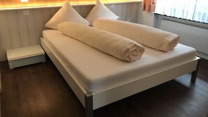 A modern hotel room with a bed, bedside tables, and a headboard with built-in lighting. - Apartment Channa by Interhome (Saas-Almagell)